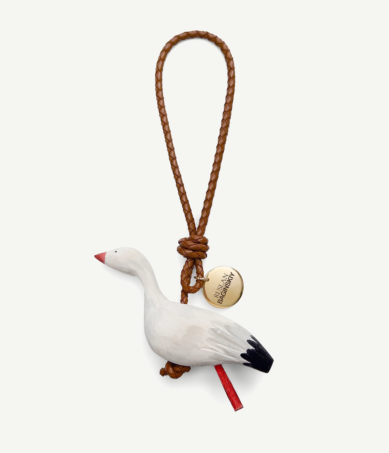 ALLwithoudDIS, RB Bag Charms embody deeply familiar symbols, each carries the emotional legacy of home. Each with its own character — a traveler or a guardian, a dreamer or a quiet observer. Hand-carved from natural wood, delicately painted each bag charm features a leather strap, and finished with an RB metal logo-medallion.The Stork — a bird that returns home every spring. A symbol of hope, awakening, and the arrival of spring. The stork carries with it the spirit of homecoming — to family, to dear traditions, to where it all began.