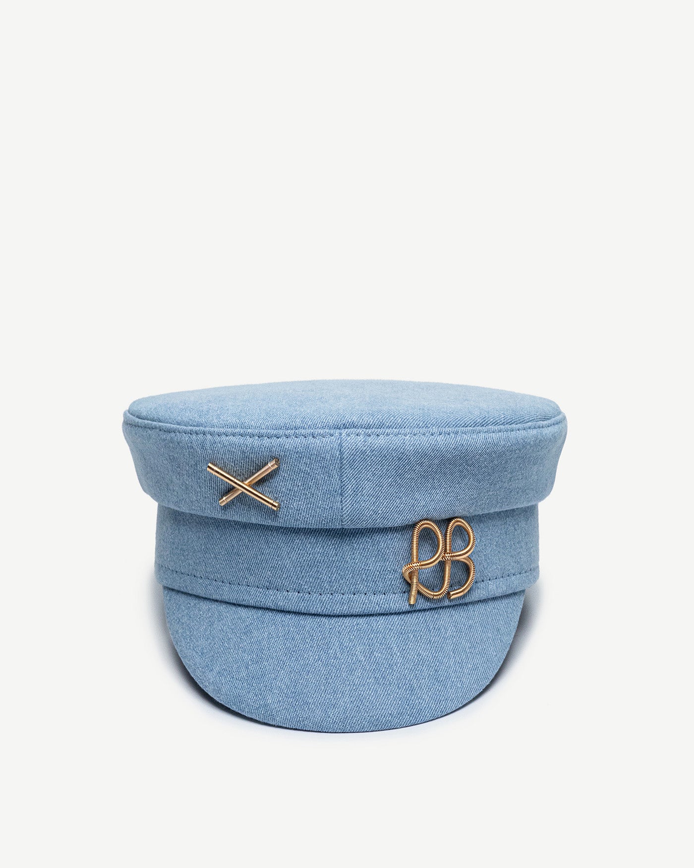 Baker Boy Cap, Ruslan Baginskiy Denim Baker Boy Cap with Gold LogoA brand bestseller, the baker boy cap is crafted from cotton in a soft blue shade. Its geometric silhouette adds structure and a distinctive stylistic accent to any look. The piece is finished with a gold-tone RB metal logo.Handmade in Ukraine.
