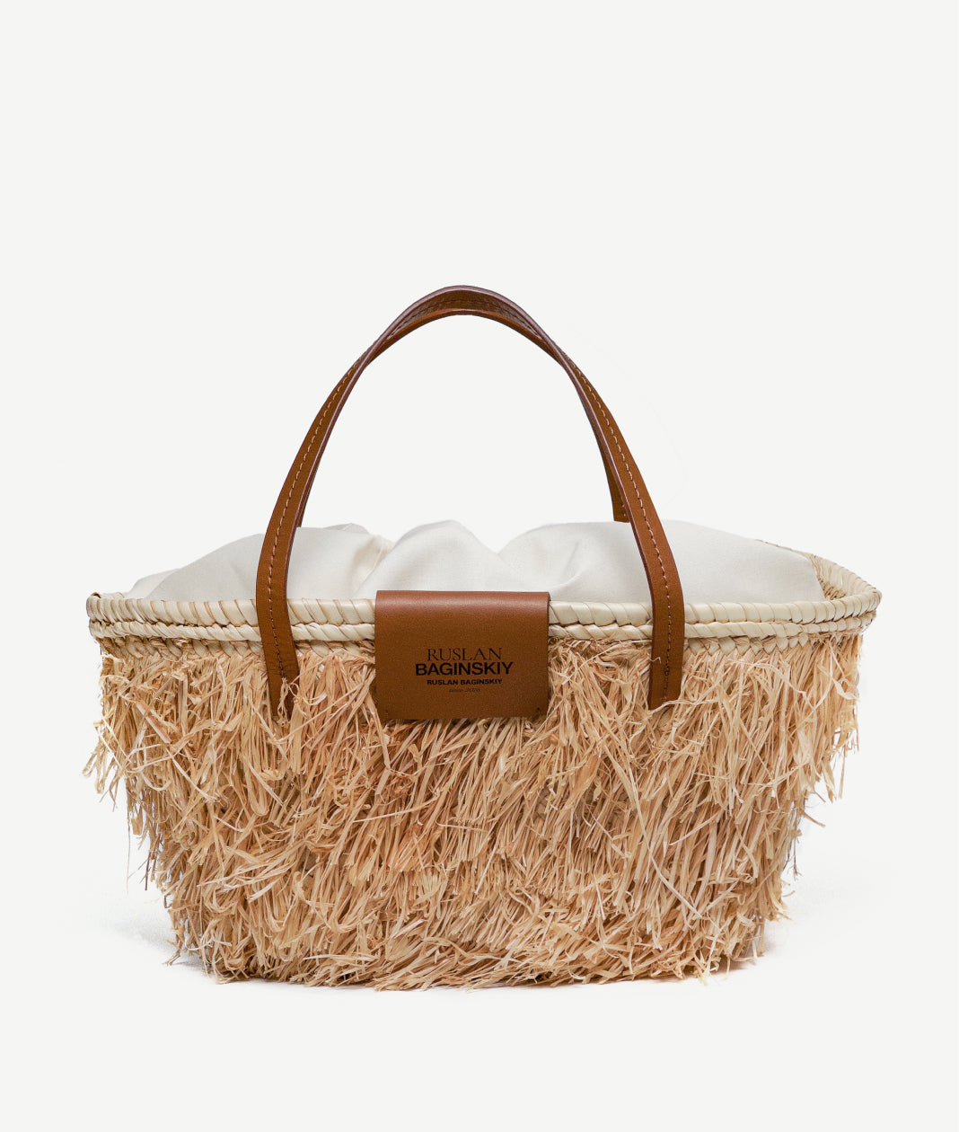 Mother’s Day Gifts, Ruslan Baginskiy "Nest" Tote BagThis bag is crafted from tightly woven natural straw, giving it a structured and durable shape. Featuring brown leather handles, it can be comfortably carried on the shoulder or by hand. The interior includes a cotton pouch to keep your essentials safe, and the bag is finished with the Ruslan Baginskiy logo for a signature touch.Handmade in Ukraine.