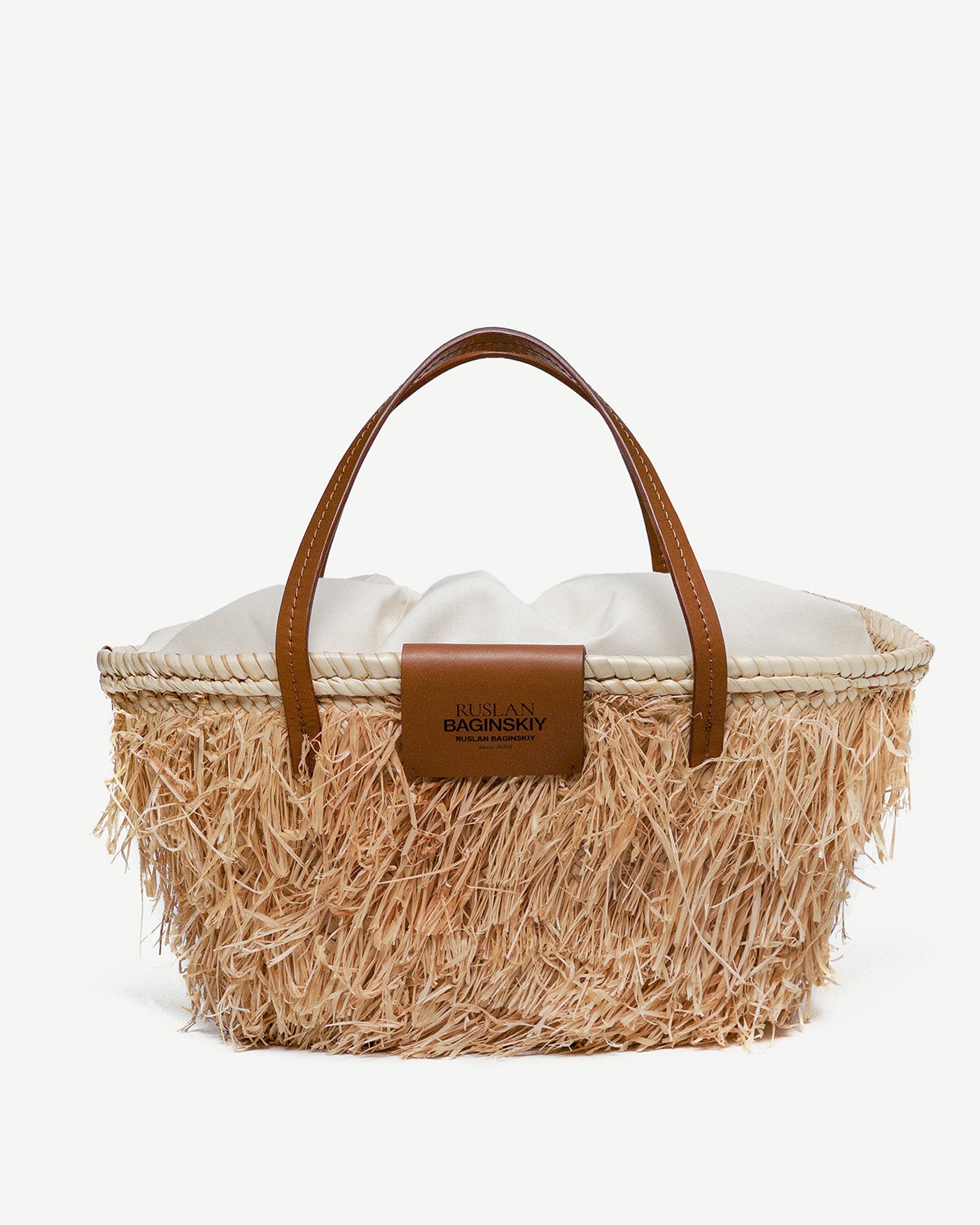 Mother’s Day Gifts, Ruslan Baginskiy "Nest" Tote BagThis bag is crafted from tightly woven natural straw, giving it a structured and durable shape. Featuring brown leather handles, it can be comfortably carried on the shoulder or by hand. The interior includes a cotton pouch to keep your essentials safe, and the bag is finished with the Ruslan Baginskiy logo for a signature touch.Handmade in Ukraine.