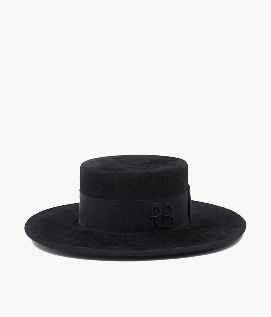 FW2021, Ruslan Baginskiy Canotier Hat — один із головних мінімалістів у нашій родині Canotier. Виконаний із тонкого фетру, прикрашений бавовняною стрічкою з вишитими вручну ініціалами RB — увесь чорний, увесь монохромний.Коли ми думаємо про «інвестиційний» капелюх, маємо на увазі модель із мінімумом деталей, переважно нейтрального відтінку та з натурального матеріалу. Цей Canotier Hat бере усі бали. Усе продумано — крім однієї деталі: щойно ви його вдягнете, можете не захотіти знімати. Ви взагалі уявляєте, як його зняти? Ми can-not-ier.